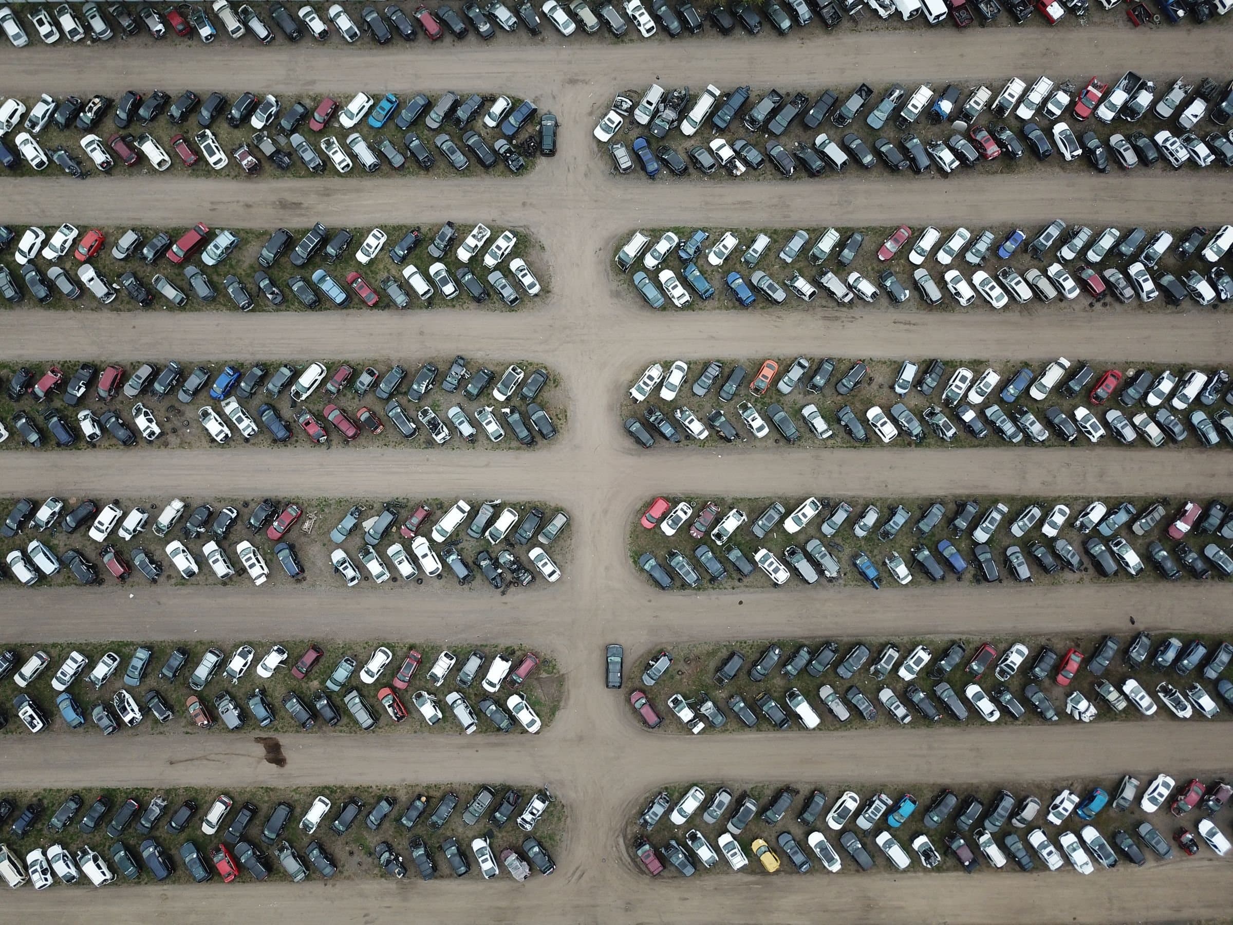 Rows of cars at a vehicle auction yard, seen from above