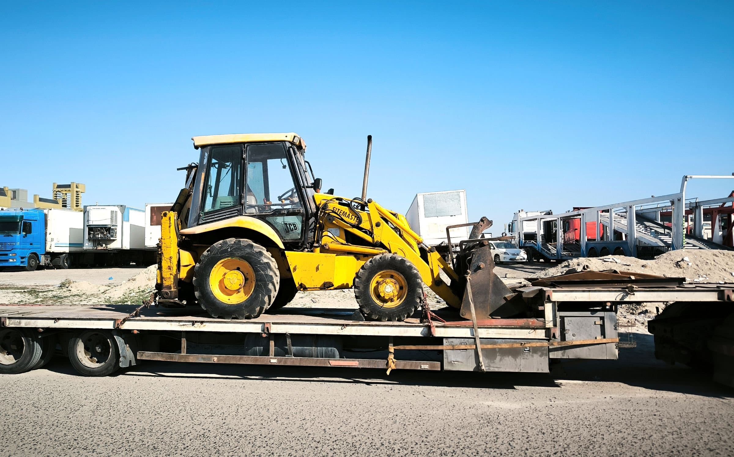 A loader strapped onto a flatbed trailer